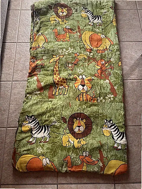 Vintage children's sleeping bag with a jungle animal print.
